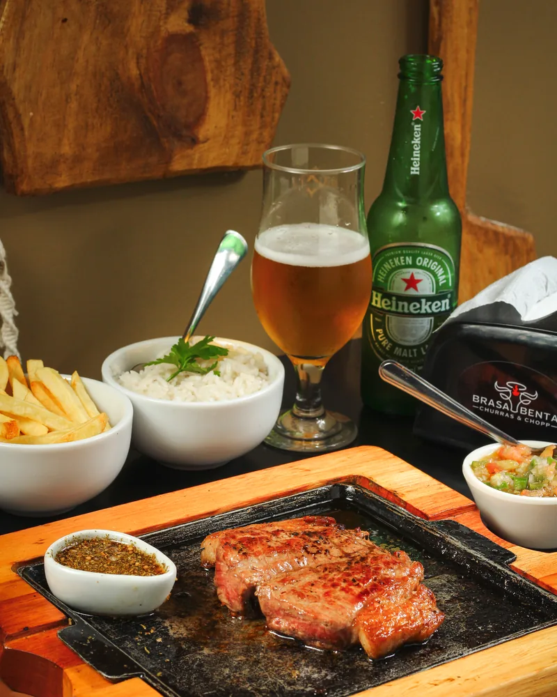 Corte de carne servido na tábua com cerveja gelada ao lado