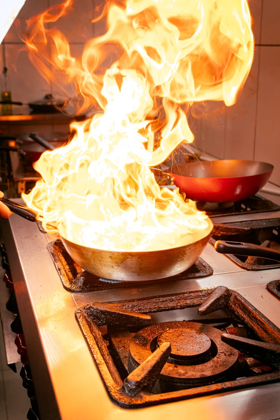 Panela pegando fogo alto no fogão da cozinha